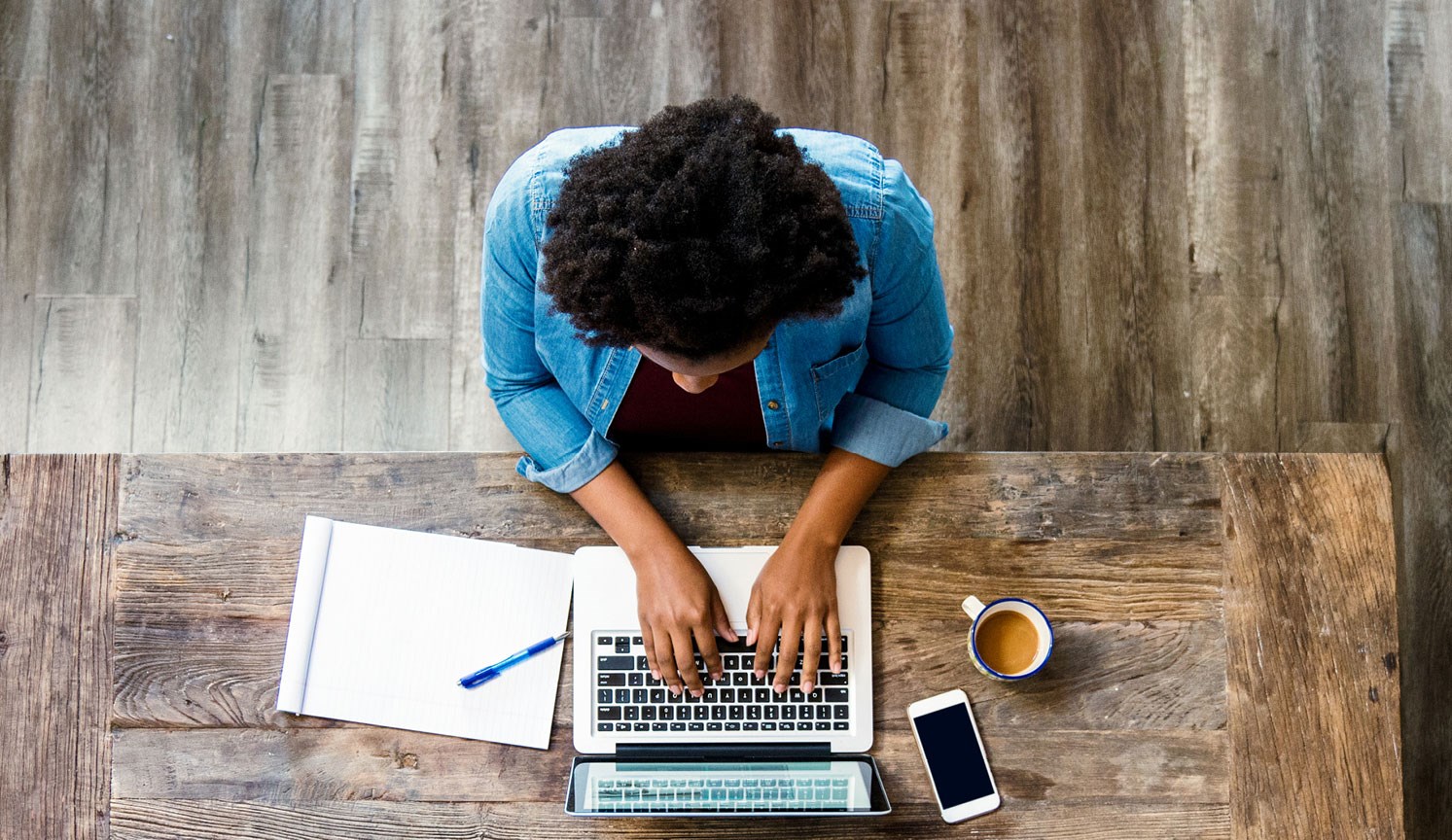 overhead view of woman working on laptop at desk